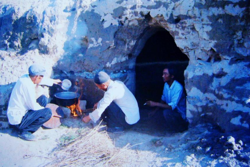 1983年,“六老漢”一代治沙人在“地窩子”生活做飯。新華社發(八步沙林場供圖)